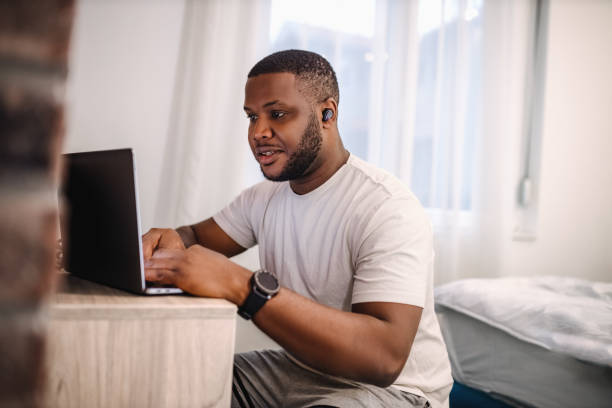 istock Young black man using laptop to play music for his home workout 2185464994