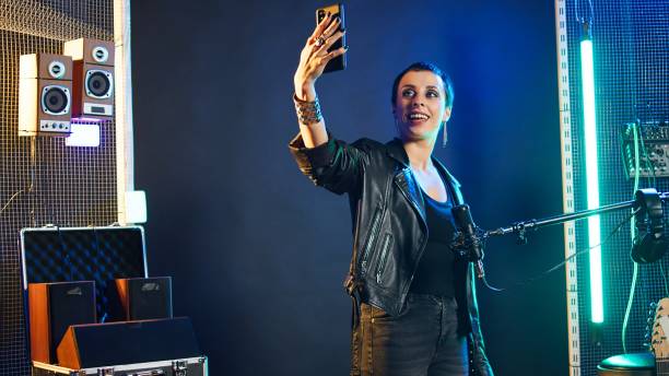 istock Rocker singer chatting on a video call and showing the studio on a selfie camera 2185470636
