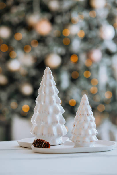istock Elegant white ceramic Christmas trees amidst blurred festive background 2185473685