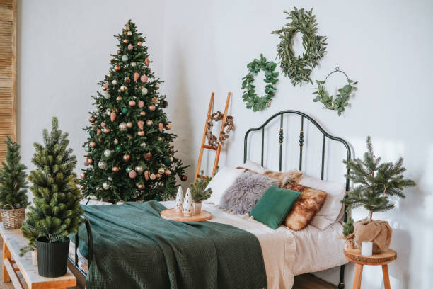 istock Cozy bedroom decorated for the holidays with a Christmas tree and greenery 2185473699