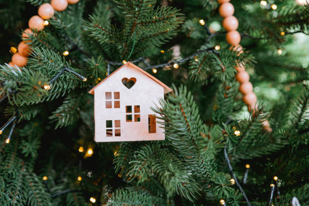istock Decorative house-shaped ornament hanging on a festive Christmas tree 2185473710