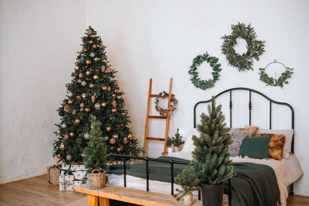 istock Cozy bedroom decorated for the holidays with a tree and festive greenery 2185473736