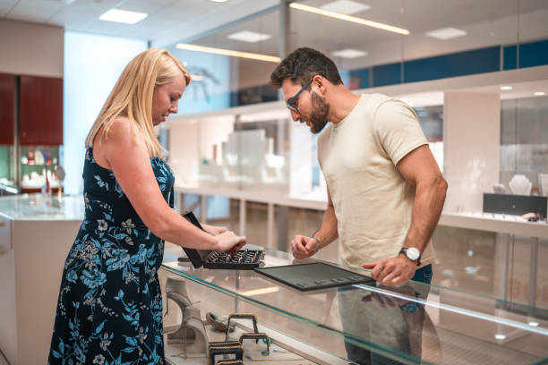 istock Hispanic Male Selecting Engagement Ring with Saleswoman 2185477111