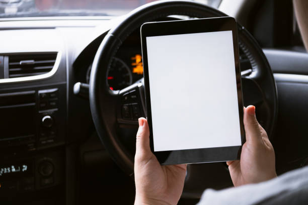 istock Woman sitting in a car and holding a tablet with blank screen. 2185494444