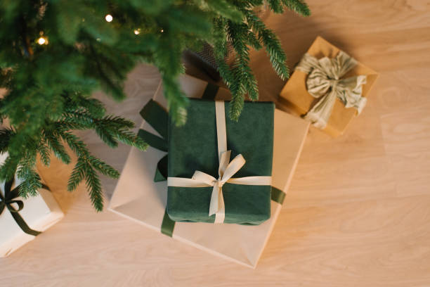 istock Green christmas gift with a bow on top of a stack of other boxes 2185494774