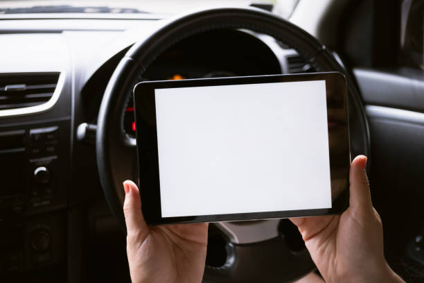 istock Woman sitting in a car and holding a tablet with blank screen. 2185494865