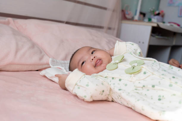 The little baby is exercising in bed