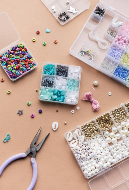 istock Crafting with colorful beads on a flat workspace with tools and containers in bright daylight 2185508031