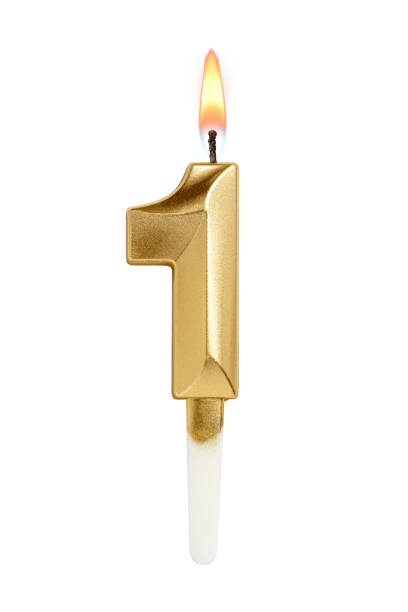 istock Golden decorated burning birthday candle digit one shaped isolated on white. 2185508713