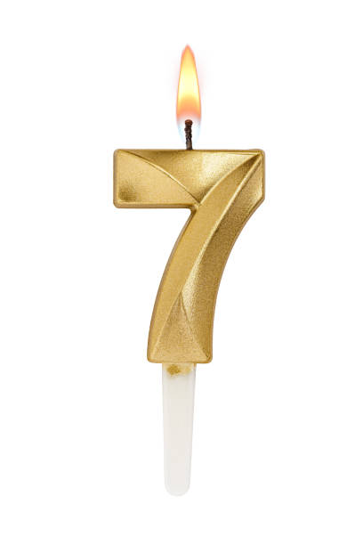 istock Golden decorated burning birthday candle digit seven shaped isolated on white. 2185508734
