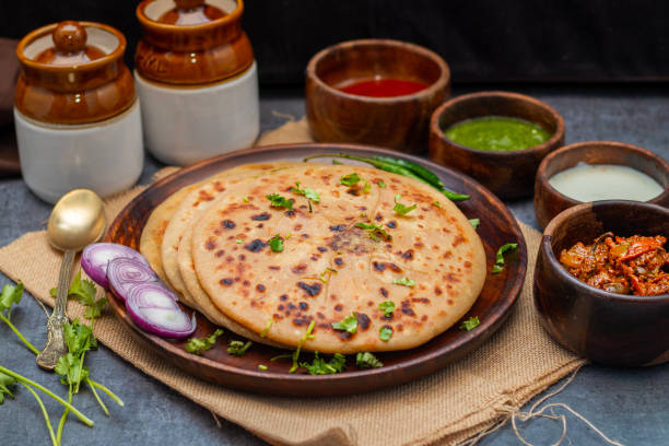 istock Aloo paratha, a golden-brown Indian flatbread stuffed with spiced mashed potatoes, is served with tangy achar (pickle) and refreshing chutney, creating a perfect blend of flavors for a comforting, savory delight. 2185512904