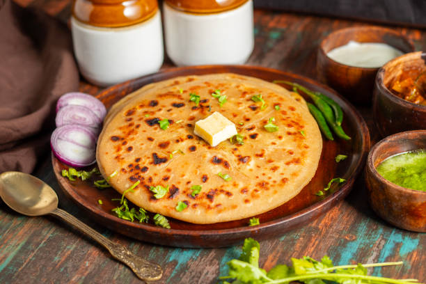 istock Aloo paratha, a golden-brown Indian flatbread stuffed with spiced mashed potatoes, is served with tangy achar (pickle) and refreshing chutney, creating a perfect blend of flavors for a comforting, savory delight. 2185512930
