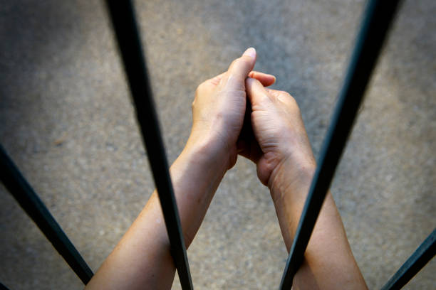 istock Hands Holding Each Other Through Bars Representing Connection, Unity, and Emotional Support in Times of Separation or Struggle in a Stark Environment 2185513327