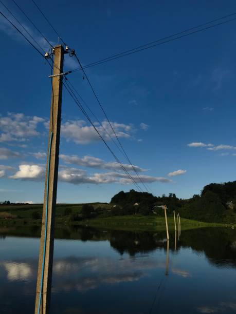 istock Tranquil rural landscape with telephone poles and cloudy sky reflection 2185517447