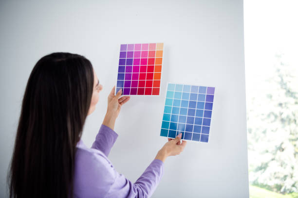 istock Woman selecting color palettes indoors, wearing casual pullover during daylight, showcasing interior design creativity and comfort at home 2185518383