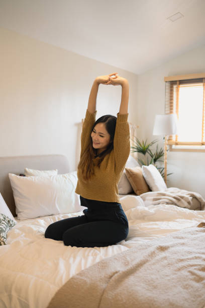 istock Happy young woman stretching n a comfortable bed for relaxing morning start 2185519554