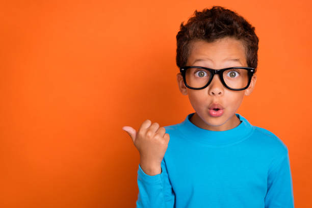 Photo of impressed boy hand direct empty space unexpected unbelievable reaction big black friday sale isolated on orange color background