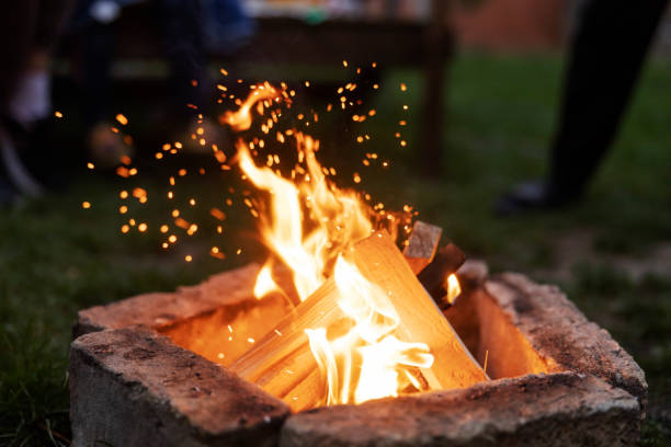 Close up of campfire and sparks burning in backyard.
