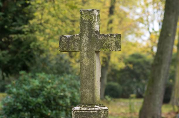 istock Old stone cross standing in cemetery during autumn 2185526864