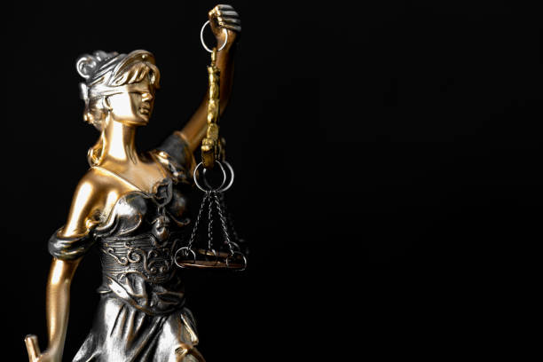 istock Lady Justice Statue Against Black Background 2185526929