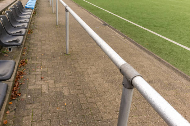 istock Empty bench and metal railing overlooking artificial turf soccer field 2185527208