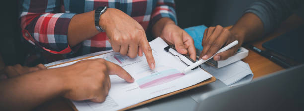 istock Group of Business people point to annual report and discussion to solution problem during brainstorming meeting. Collaborate between Professional Businessman and Partnership. Strategy Business concept 2185527623