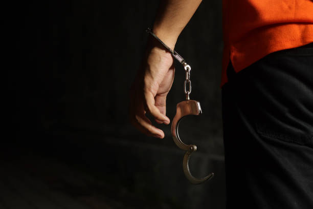 istock Criminal suspect arrested with hands in handcuff. Dramatic light portrait 2185528799