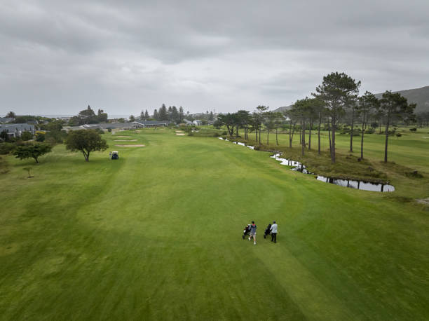istock Golfers walking on green fairway on overcast day at golf course 2185529798
