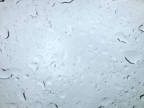 istock Raindrops sliding on glass surface during rainy day 2185529952