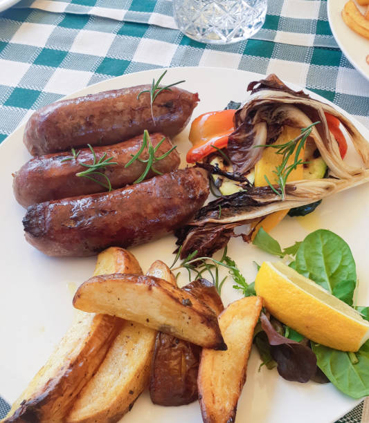 istock Grilled sausages with roasted potatoes and vegetables on a plate 2185529954