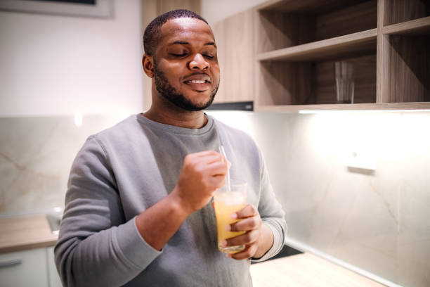 istock Young black man drinking refreshing juice in the kitchen 2185530891