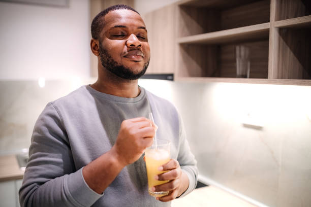 istock Young black man drinking refreshing juice in the kitchen 2185530908