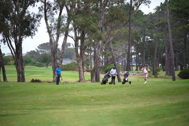 istock Group of golfers play their second shots from the fairway 2185531024