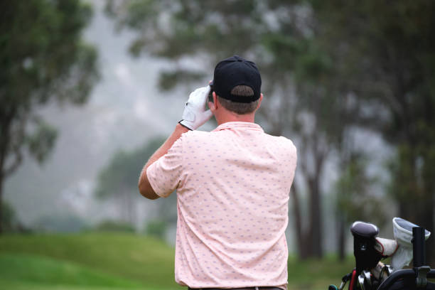Man playing golf on a well-maintained course, focusing on putting. Beautiful sunny day at a resort.