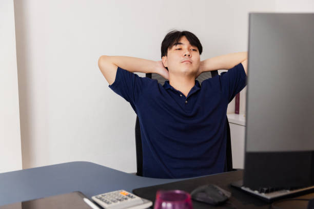 istock Young man relaxing at desk in a modern workspace during a break from work 2185531641
