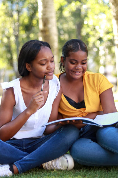 istock Two Black women students sitting, brainstorming and writing in a notebook 2185531885