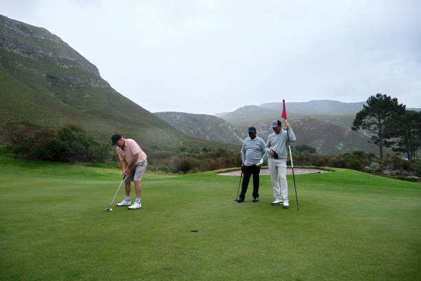 istock Golfers putting on green with mountain view 2185532005