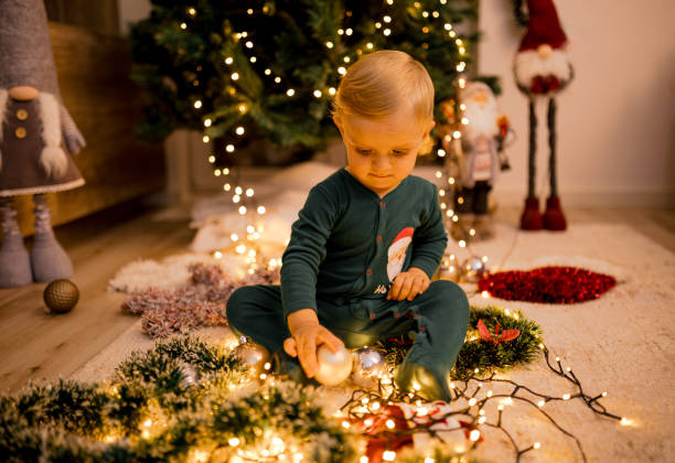 istock Joyful Toddler Sitting Under Christmas Tree With Ornaments 2185532082