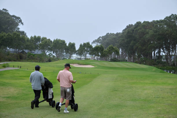 istock Golfers walking on lush green fairway on overcast day 2185532265