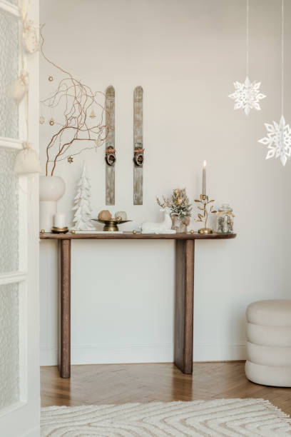 istock Rustic console table with winter decorations, vintage skis, and snowflake ornaments. Perfect for a cozy holiday atmosphere. 2185532390