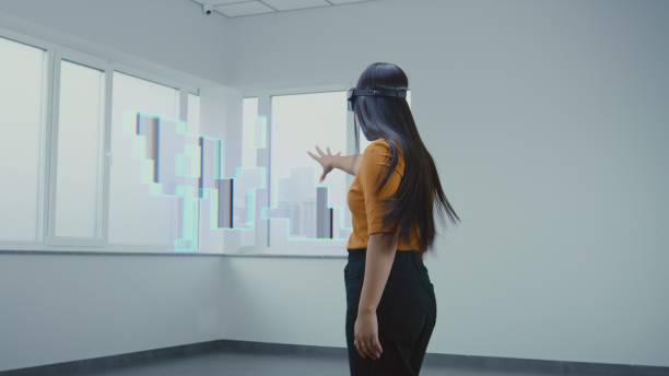 istock Asian female designer in VR headset creates interior in office room in 3D virtual space 2185533184