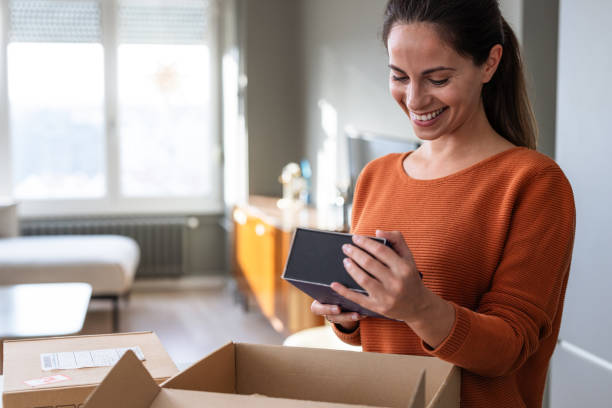 istock Surprise moment: Woman unpacks her package with joy 2185534048