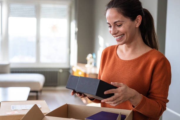 istock At-home happiness: Woman unboxing her online purchase 2185534052
