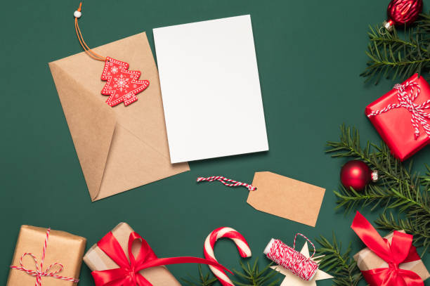 istock Christmas card, background. Paper gift boxes and an envelope with a blank card framed by coniferous branches. Copy space. Boxing Day concept. 2185534397