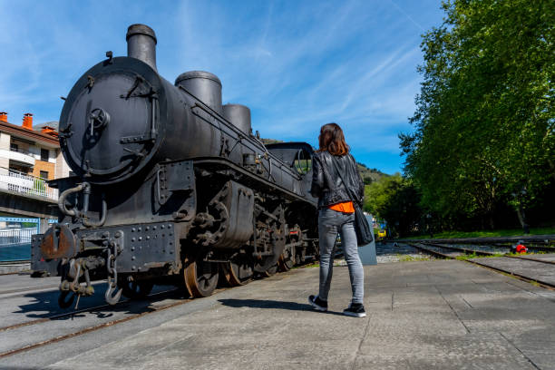 istock A woman stands in front of an old train engine 2185534900