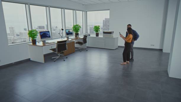 Well-organized office space with desks, computers, plants, and documents Creating an efficient and welcoming workplace environment