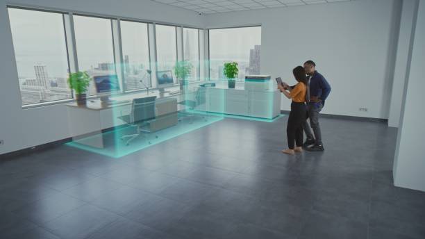 istock Team of two designers using app on tablet computer to design interior in office room with 3D furniture 2185536398