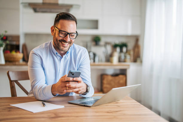 istock A 36-year-old cheerful, handsome businessman sitting in the kitchen and using a laptop. 2185536644