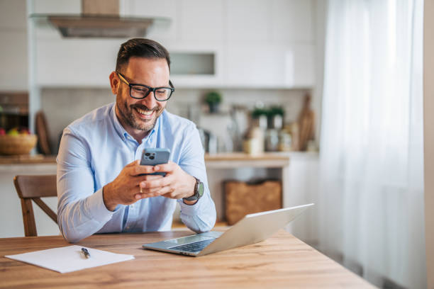 istock A 36-year-old cheerful, handsome businessman sitting in the kitchen and using a laptop. 2185536822