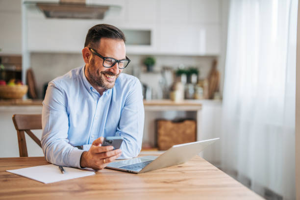 istock A 36-year-old cheerful, handsome businessman sitting in the kitchen and using a laptop. 2185536826